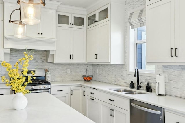 kitchen featuring white cabinetry, stainless steel appliances, light countertops, and a sink