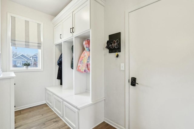 mudroom featuring light wood finished floors and baseboards