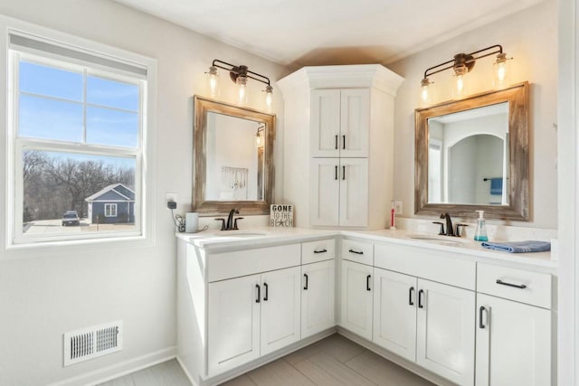 full bath featuring double vanity, visible vents, and a sink