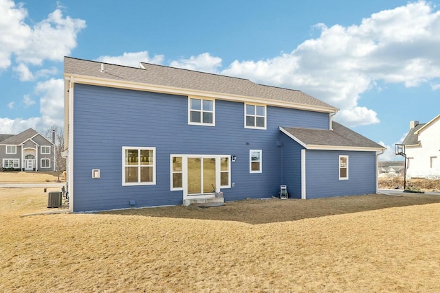 rear view of house featuring central AC and a shingled roof