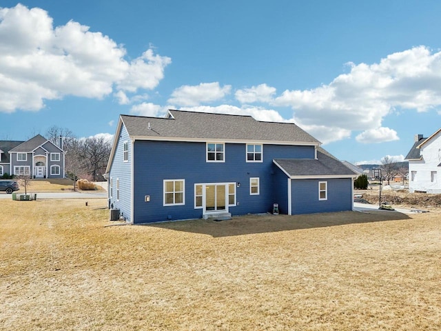 rear view of house with cooling unit and a yard