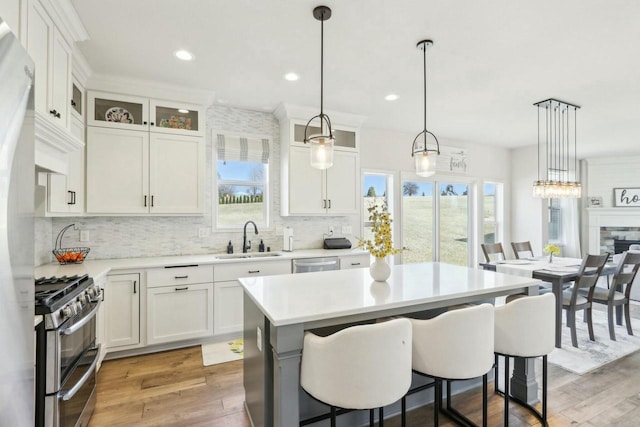 kitchen featuring tasteful backsplash, stainless steel appliances, light countertops, and a sink