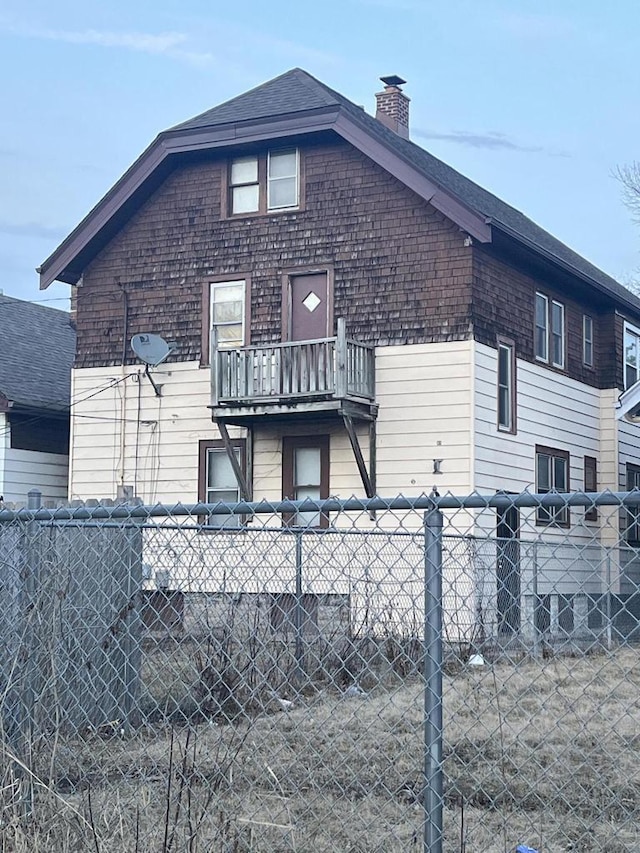 exterior space featuring fence private yard, roof with shingles, and a chimney