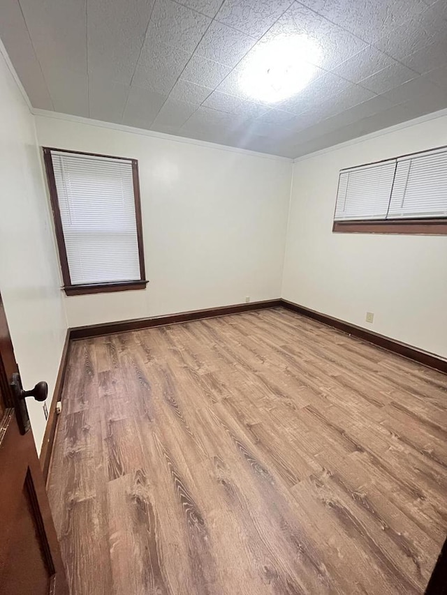 empty room with baseboards and wood finished floors