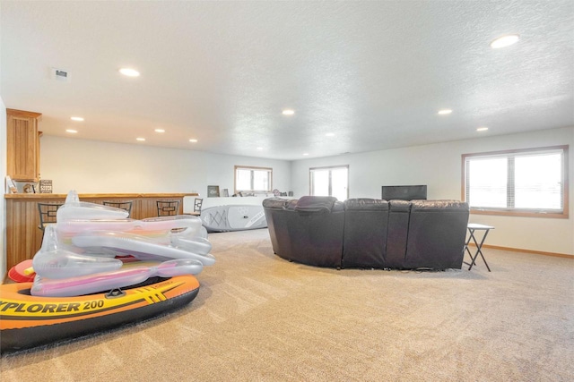 living room featuring recessed lighting, baseboards, light carpet, and a textured ceiling