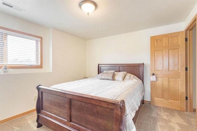 carpeted bedroom with visible vents and baseboards