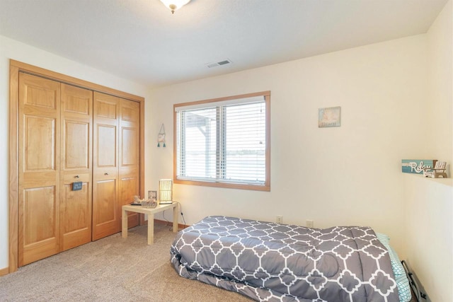 carpeted bedroom with a closet and visible vents