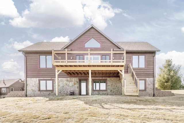 back of property featuring stairway, a shingled roof, a wooden deck, and stone siding