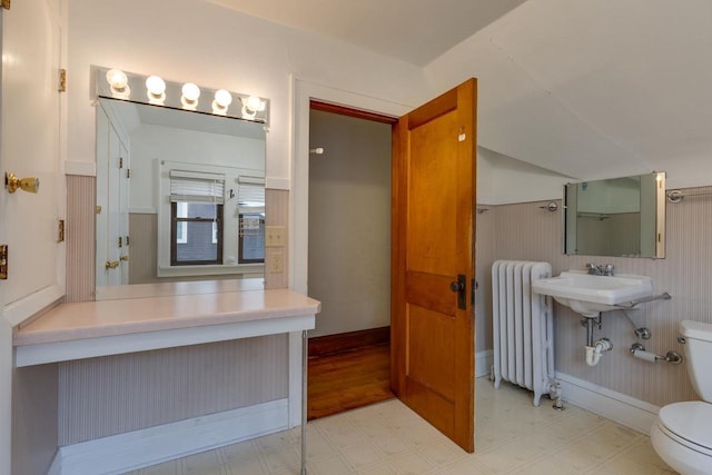 bathroom with tile patterned floors, radiator, wainscoting, and toilet