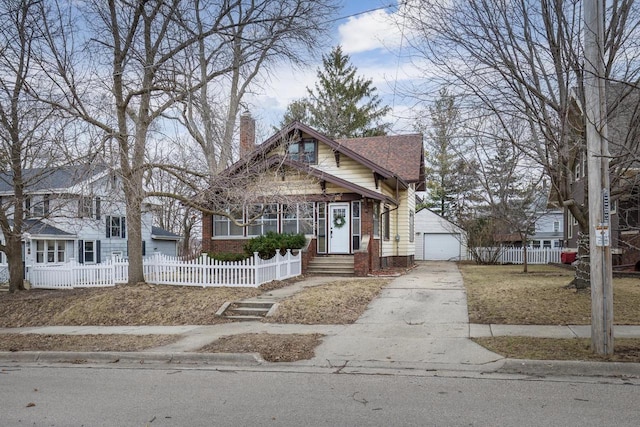 view of front of house with brick siding, a fenced front yard, a chimney, a garage, and driveway