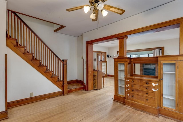 interior space with a ceiling fan, stairway, wood finished floors, and baseboards