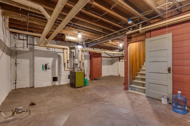 unfinished basement with heating unit and stairway