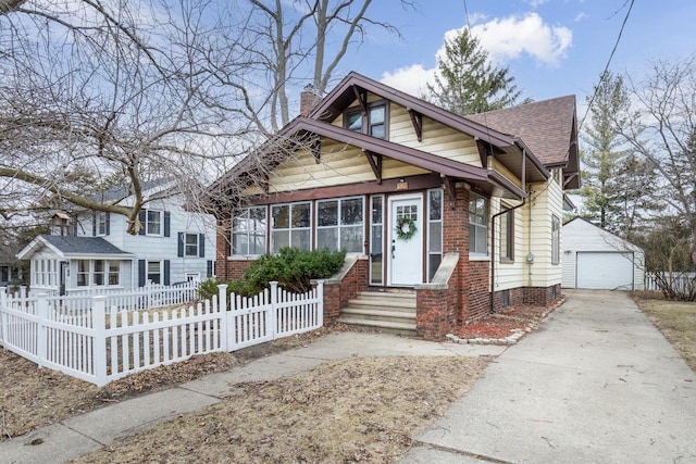 bungalow-style home featuring a shingled roof, a chimney, an outdoor structure, a fenced front yard, and a detached garage