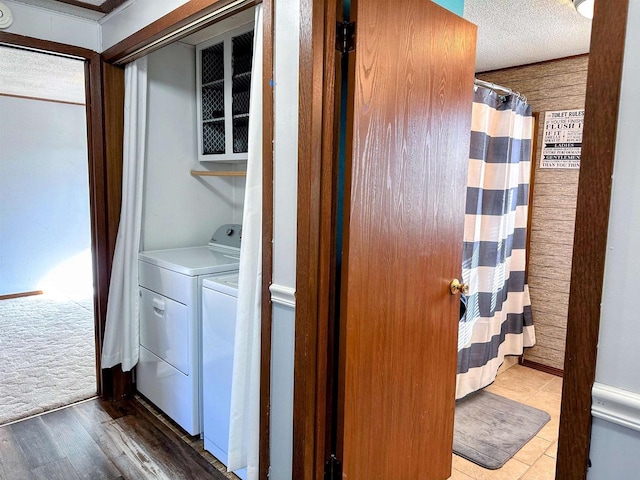 laundry area with washer and dryer, a textured ceiling, wood finished floors, and laundry area