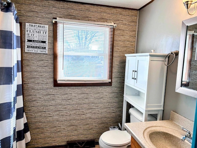 bathroom with vanity, ornamental molding, wood walls, curtained shower, and toilet