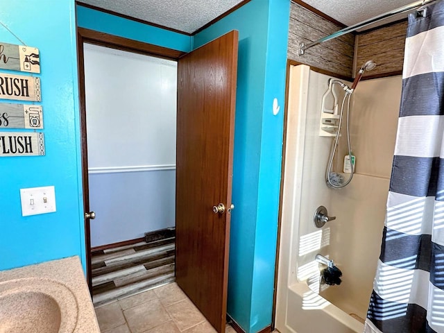 full bath featuring a sink, a textured ceiling, and shower / tub combo with curtain