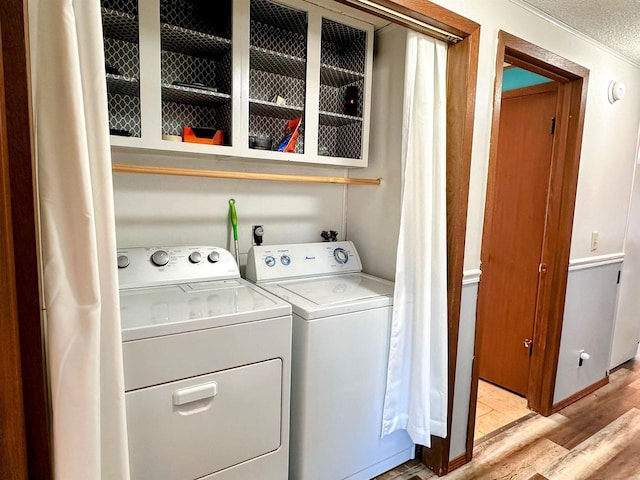 washroom featuring washing machine and clothes dryer, laundry area, and light wood-style floors