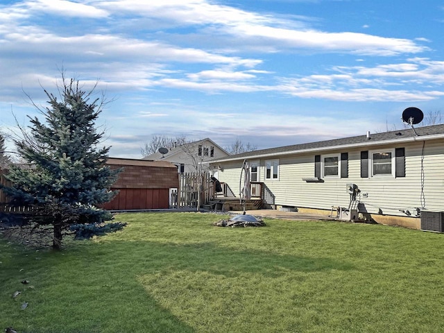 rear view of property with a lawn and central AC