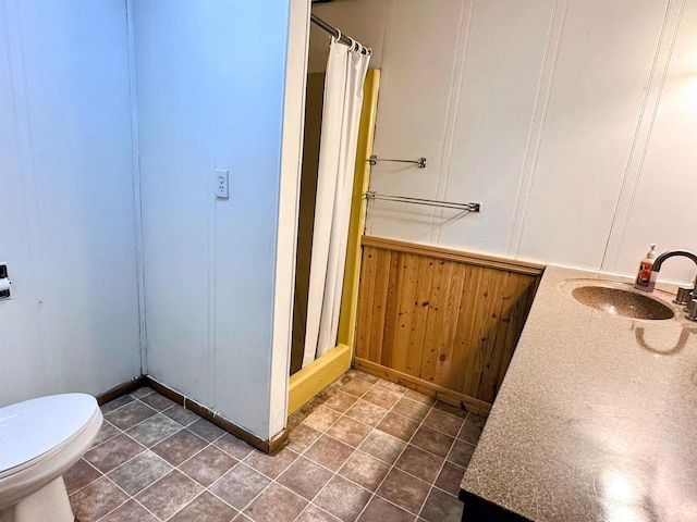 bathroom featuring tile patterned floors, a stall shower, toilet, and a sink