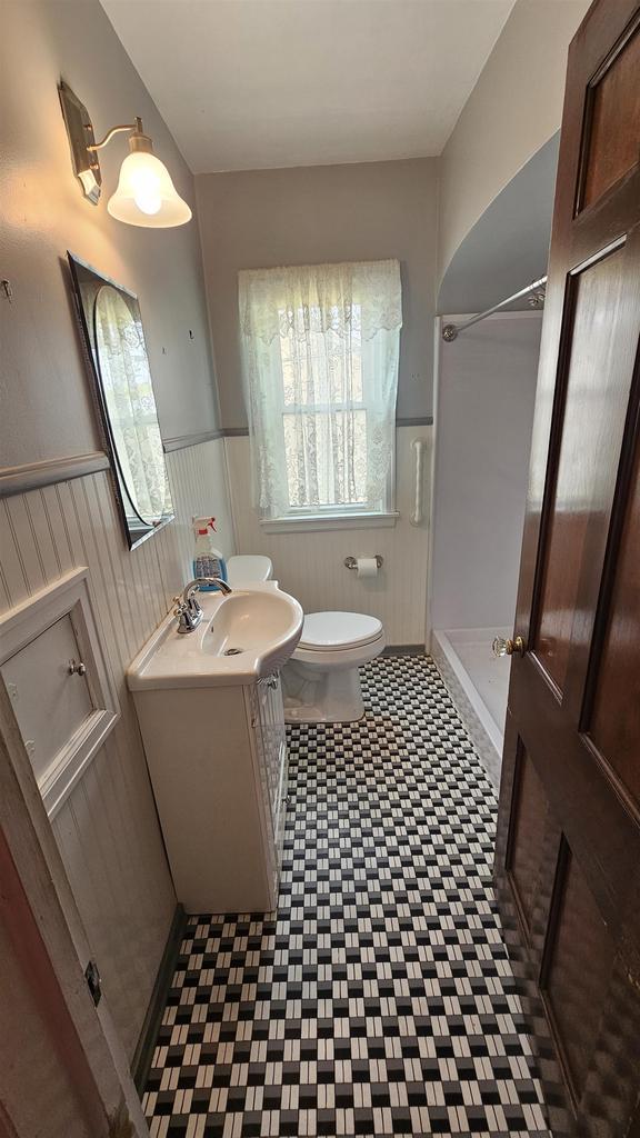 full bath with vanity, toilet, a shower, and a wainscoted wall