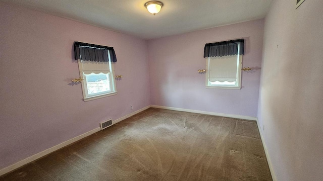 carpeted empty room with visible vents and baseboards