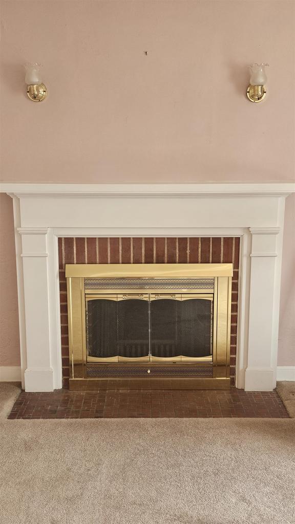 room details with baseboards, a brick fireplace, and carpet flooring