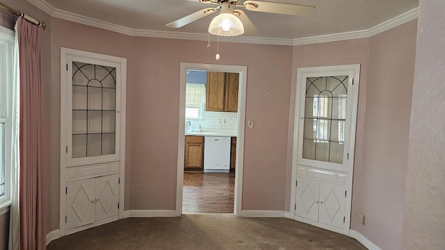 interior space with crown molding, baseboards, and dark colored carpet