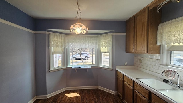 kitchen with a sink, decorative backsplash, plenty of natural light, and dark wood-style floors