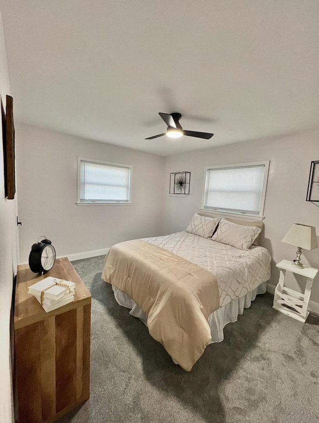 bedroom with dark carpet, a ceiling fan, and baseboards