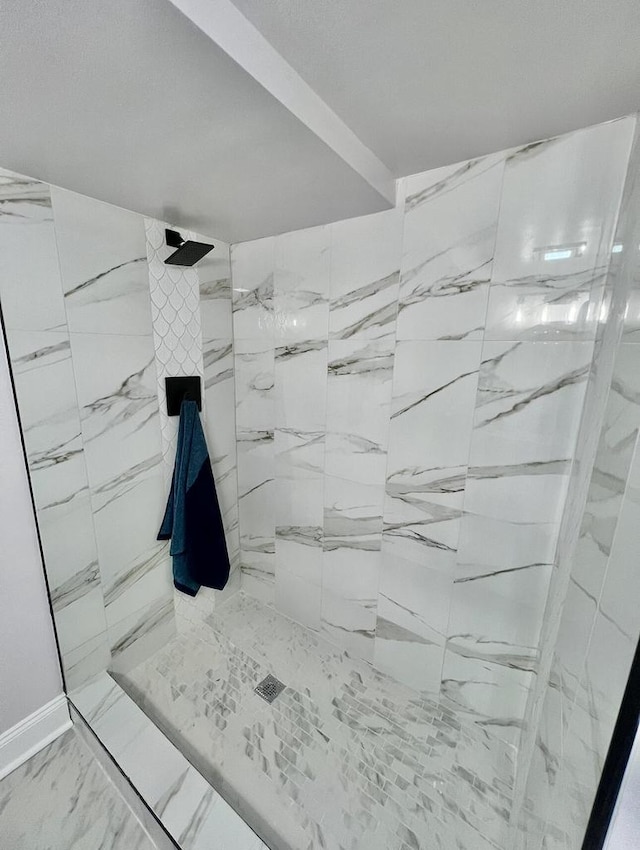 full bathroom with tiled shower and marble finish floor