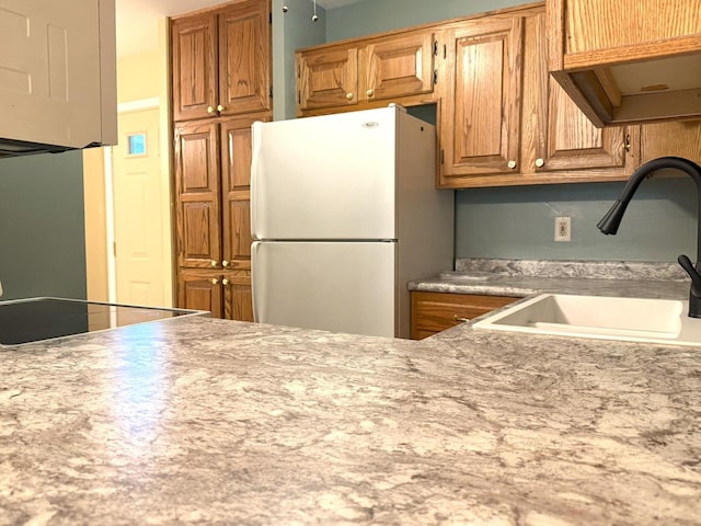 kitchen with a sink, light countertops, and freestanding refrigerator