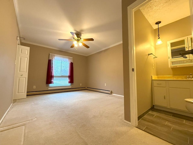 interior space with a baseboard heating unit, baseboards, crown molding, and a ceiling fan