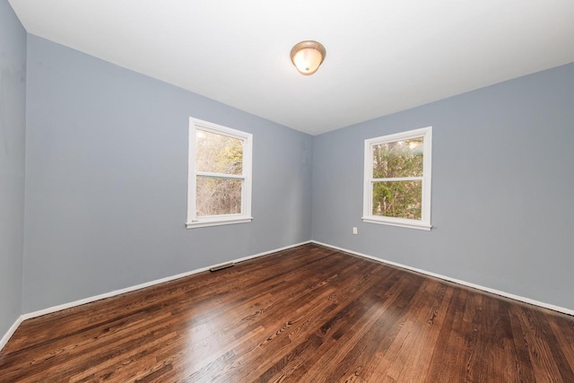 empty room with dark wood finished floors and visible vents