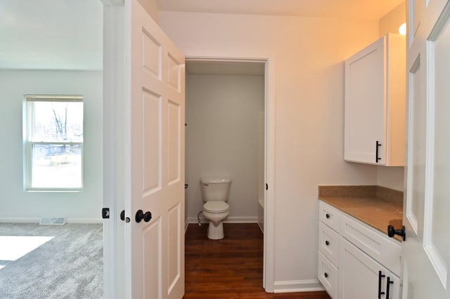 bathroom with visible vents, toilet, vanity, and baseboards