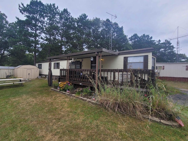 back of house with an outbuilding, a wooden deck, a storage unit, and a yard