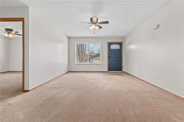 interior space with a textured ceiling, baseboards, and ceiling fan