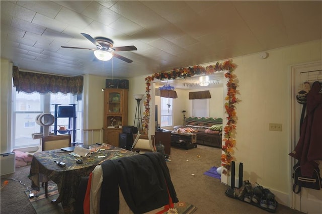 carpeted dining space with ceiling fan