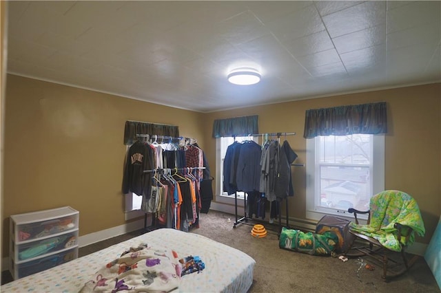 carpeted bedroom featuring multiple windows and baseboards