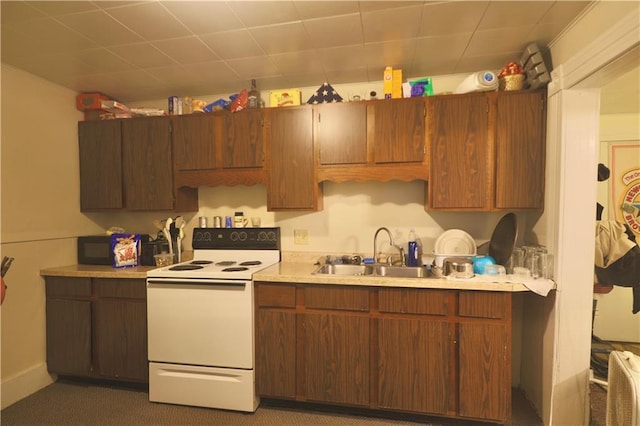 kitchen with light countertops, electric stove, black microwave, and a sink