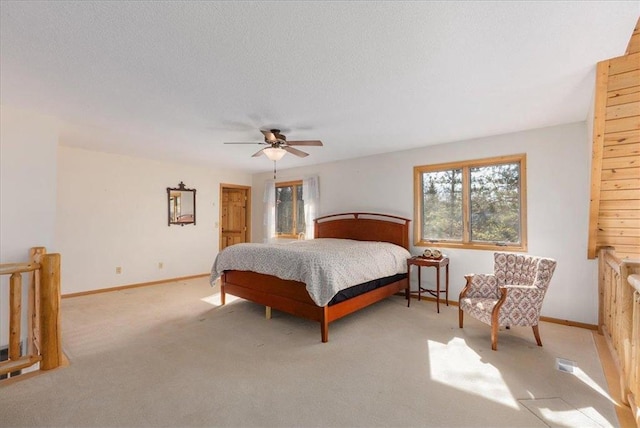 bedroom with baseboards, a textured ceiling, carpet floors, and a ceiling fan