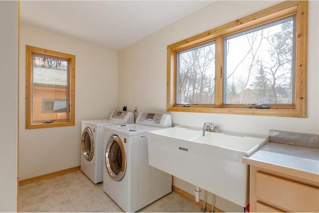 laundry area featuring a sink, baseboards, laundry area, and washer and clothes dryer