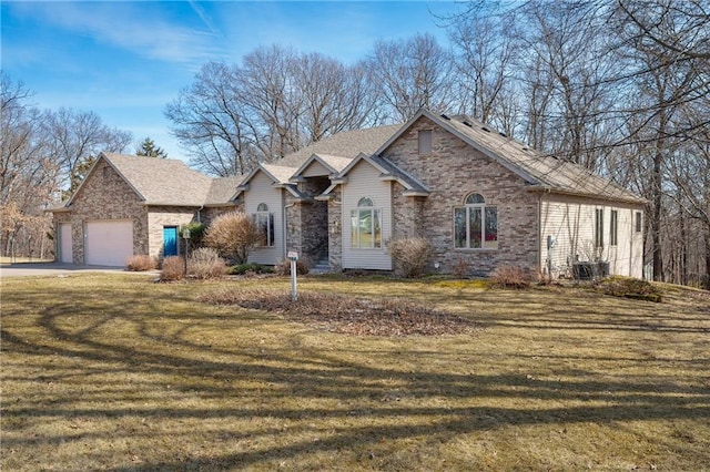 view of front of house with driveway, a front lawn, cooling unit, an attached garage, and brick siding