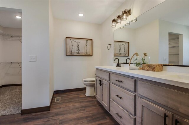 3557 114th St, Chippewa Falls, WI 54729 - full bath featuring double vanity, visible vents, toilet, a sink, and baseboards