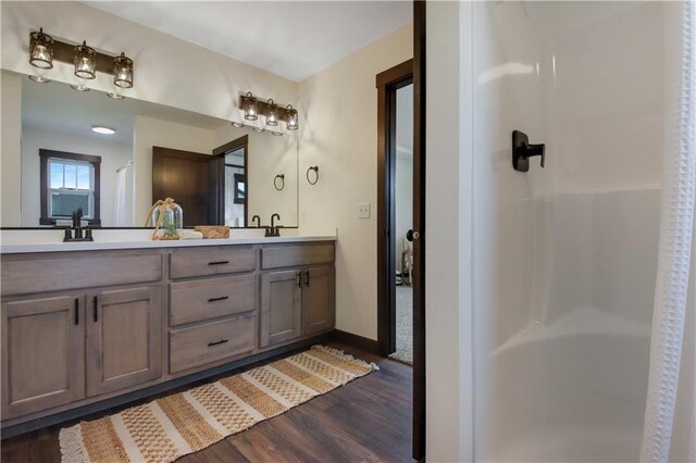 3557 114th St, Chippewa Falls, WI 54729 - full bath with double vanity, wood finished floors, a sink, baseboards, and walk in shower