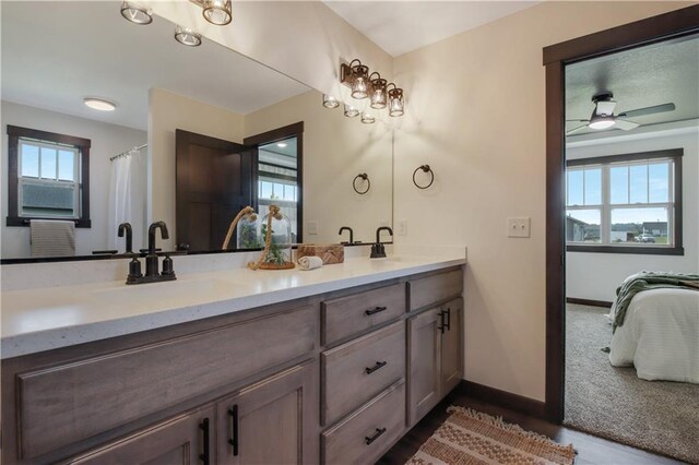 3557 114th St, Chippewa Falls, WI 54729 - full bathroom featuring a sink, double vanity, baseboards, ceiling fan, and connected bathroom