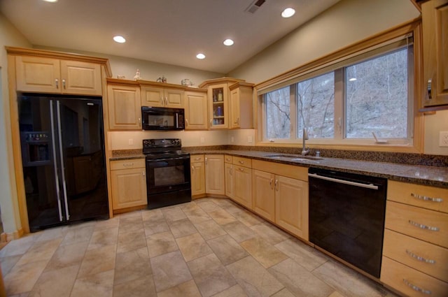 kitchen featuring a sink, dark stone counters, black appliances, and light brown cabinets