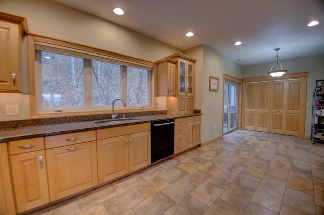 kitchen with a sink, dark stone countertops, black dishwasher, recessed lighting, and glass insert cabinets