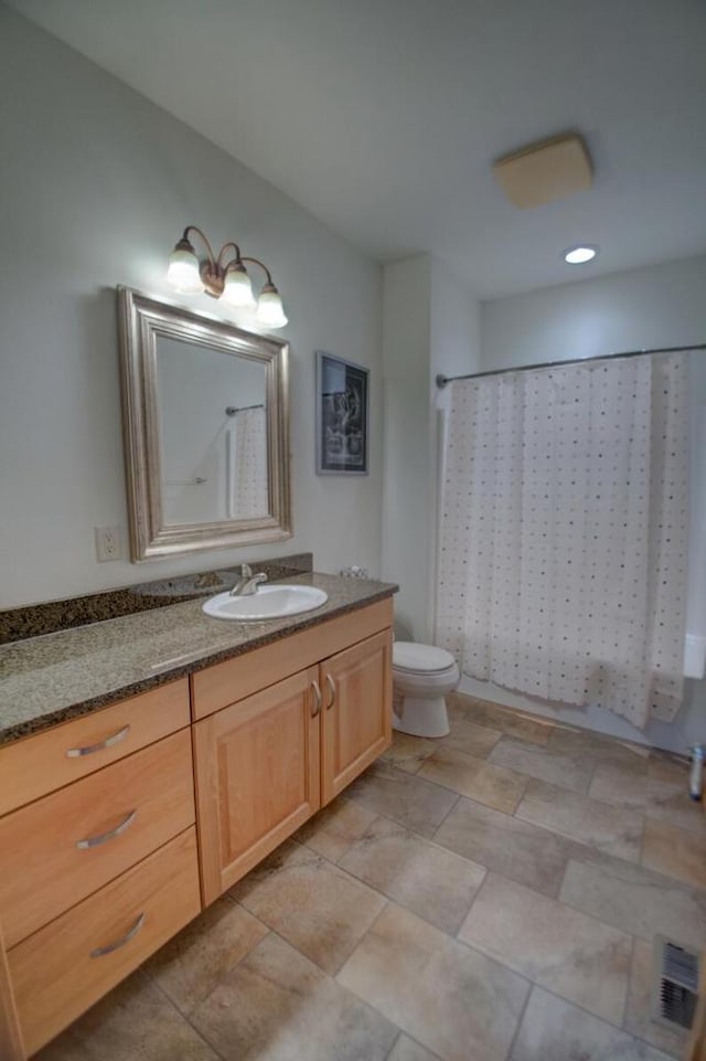 bathroom with visible vents, toilet, and vanity