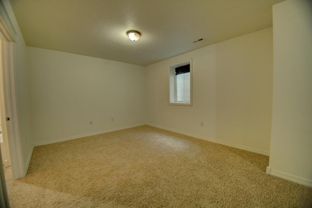 unfurnished room featuring visible vents, baseboards, and carpet