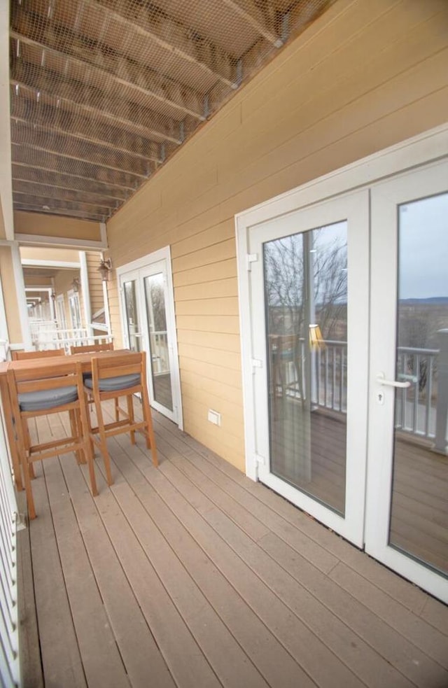 wooden deck with french doors and outdoor dining area